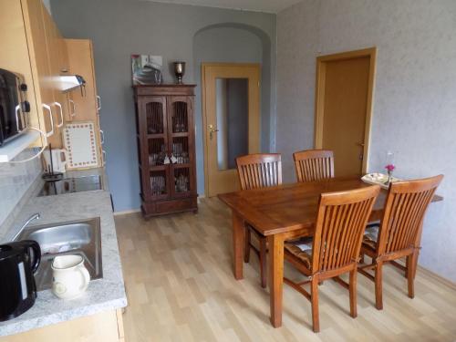 a dining room with a wooden table and chairs at Die Alte Bäckerei in Jöhstadt