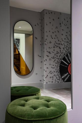 a room with two green stools and a mirror at The Starling Atlanta Midtown, Curio Collection by Hilton in Atlanta