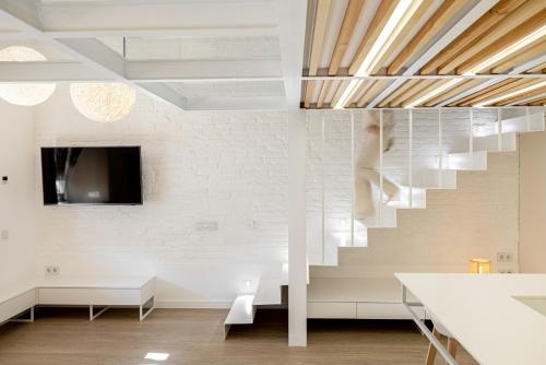a staircase in a living room with white walls at White Fox - sauna - in Lviv