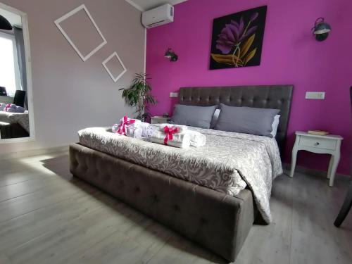 a bedroom with a bed with a purple wall at Dimora Bed and Breakfast in San Gavino Monreale
