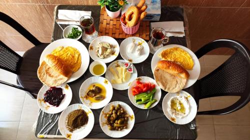Una mesa con muchos platos de comida encima. en Petra Rest Home, en Wadi Musa