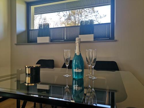 a bottle of wine and two wine glasses on a table at Dream House in Gdów