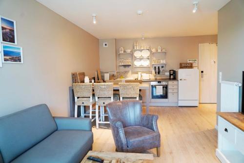 a living room with a couch and a kitchen at Beach Apartments Heiligenhafen in Heiligenhafen