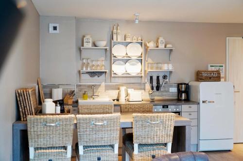 a kitchen with a table and chairs and a refrigerator at Beach Apartments Heiligenhafen in Heiligenhafen