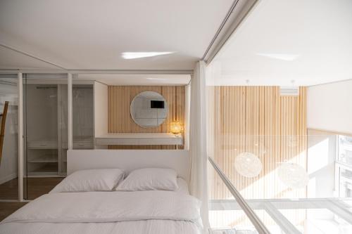 a bedroom with a white bed and a mirror at White Fox - sauna - in Lviv