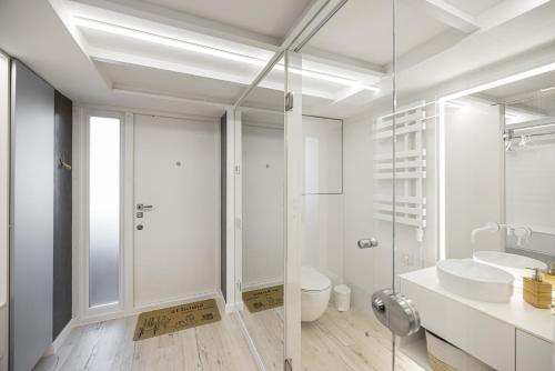 a white bathroom with a sink and a toilet at White Fox - sauna - in Lviv