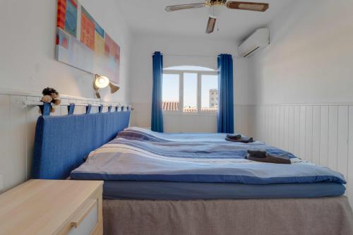 1 dormitorio con cama azul y cortinas azules en Cosy apartment in Verano Azul, en Nerja