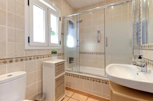 y baño con aseo, lavabo y ducha. en Cosy apartment in Verano Azul, en Nerja