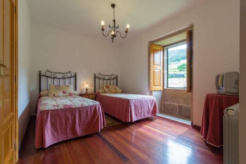 a bedroom with two beds and a window at Casa da Roncha in Noya