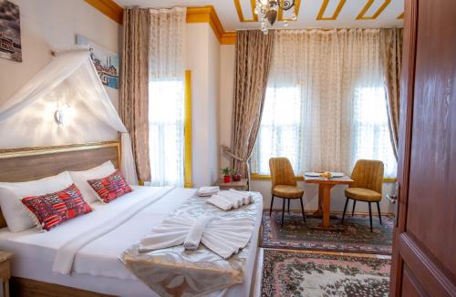 April Story Apart Hotel في إسطنبول: غرفة نوم بسرير وطاولة مع كراسي