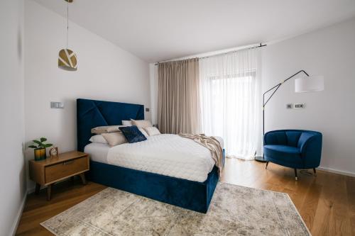 a bedroom with a blue bed and a blue chair at Apartamento Edificio Seculo XXI Vista do Mar in Funchal