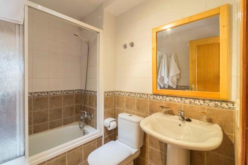 a bathroom with a toilet and a sink and a tub at Casa da Roncha in Noya