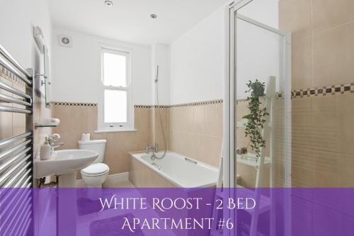 a bathroom with a white root bed apartment at The Roost Group - Bedford House Apartments in Gravesend