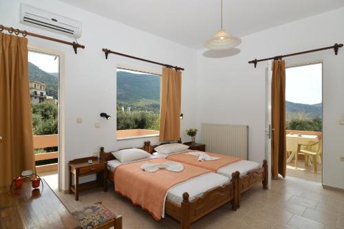 ein Schlafzimmer mit einem Bett und einem großen Fenster in der Unterkunft Niriida in Sfinárion