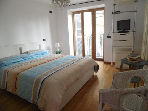 a bedroom with a bed and a tv and a chair at A Casa di Monica in Pozzuoli