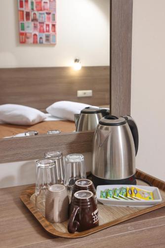 a tray with a tea kettle and glasses on a table at Summer Beach Hotel in Polykhrono