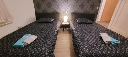 2 camas individuales en un dormitorio con toallas. en Ermis Apartments, en Metzingen