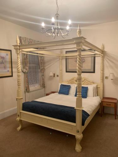 ニューポートにあるザ ウォータールー ホテル ＆ ビストロのベッドルーム(白い天蓋付きベッド、青い枕付)