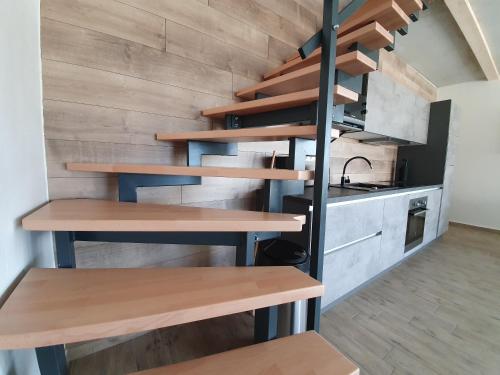 a kitchen with wooden shelves and a staircase in a room at Relax Vila Lipno 1 u pláže Windy Point in Černá v Pošumaví
