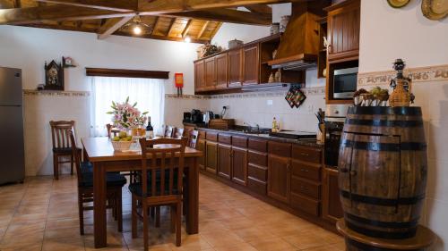 a kitchen with wooden cabinets and a table with a barrel at Quinta Rico in Quatro Ribeiras