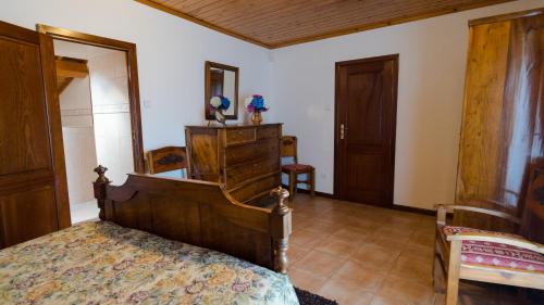 a bedroom with a bed and wooden furniture at Quinta Rico in Quatro Ribeiras