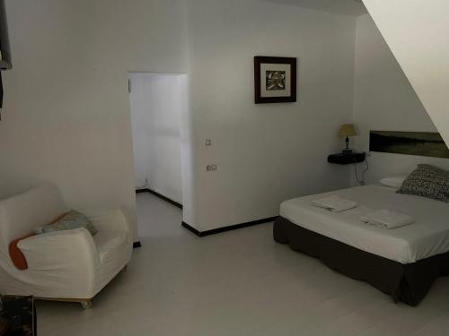 a bedroom with a bed and a chair in it at Casas de Sevilla - Apartamento Puente de Triana in Seville