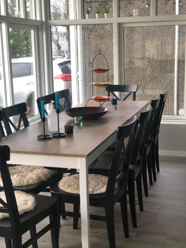 a dining room table with chairs and a large window at Varmi Guesthouse Apartments & rooms in Hveragerði