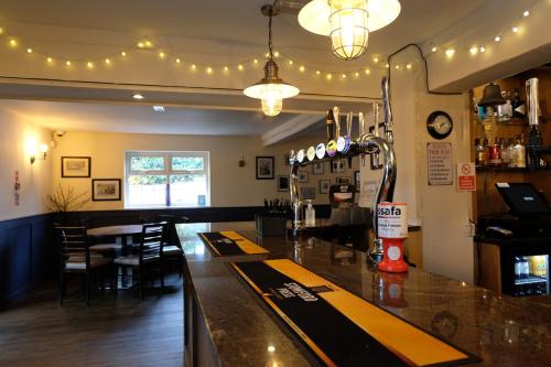 a bar in a restaurant with a table and chairs at The Lawns Hotel in Derby