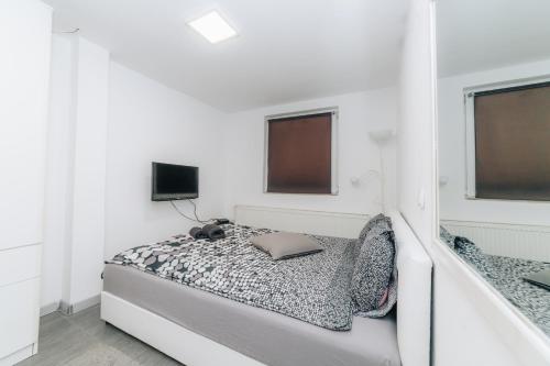 a white room with a bed with a laptop on it at Apartments Luka in Kragujevac