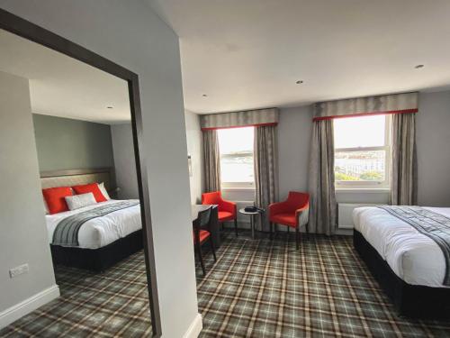 a hotel room with two beds and a mirror at Belmont Llandudno in Llandudno