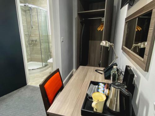 a room with a desk with a sink and a shower at Belmont Llandudno in Llandudno
