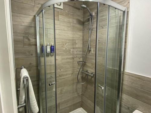 a shower with a glass door in a bathroom at Belmont Llandudno in Llandudno