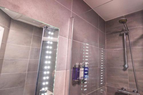 a bathroom with a shower with a glass door at Belmont Llandudno in Llandudno