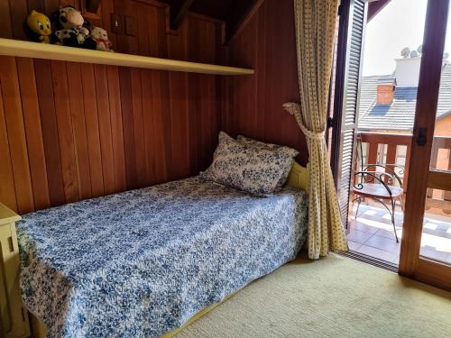ein kleines Schlafzimmer mit Bett und Balkon in der Unterkunft Duplex aconchegante no Buganvilias Flat in Gramado