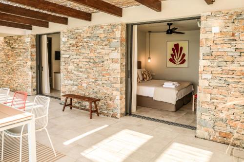 une terrasse avec un lit et une chambre avec un mur en briques dans l'établissement Skiathos Symbol Villas, à Achladies