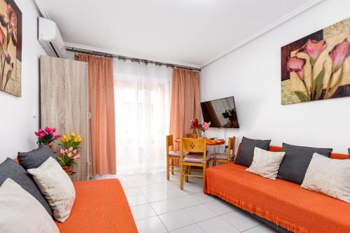 een woonkamer met 2 oranje banken en een tafel bij Apartment Studio Relax Almudena in Torrevieja