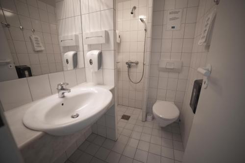 ein Bad mit einem Waschbecken und einem WC in der Unterkunft Torp Hotel in Sandefjord