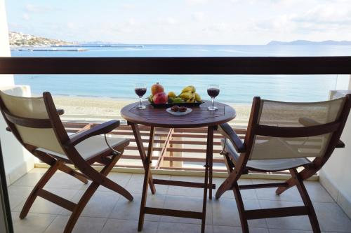 a table with a bowl of fruit and glasses of wine at Sitia Bay in Sitia
