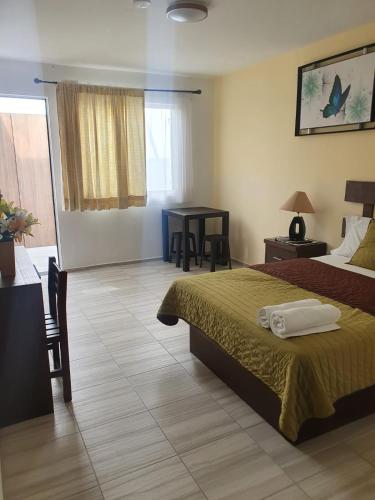 a hotel room with a bed and a table at Hotel Quinta Las Fuentes Bernal in Bernal
