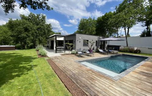 a backyard with a swimming pool and a house at Le Clos des Bleynoux in Saint-Étienne-de-Fontbellon
