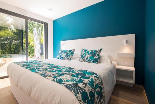 a bedroom with a large bed with a blue wall at Le Clos des Bleynoux in Saint-Étienne-de-Fontbellon
