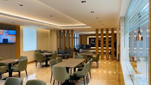SITARA HOTEL APARTMENT في دبي: مطعم بطاولات وكراسي ونافذة