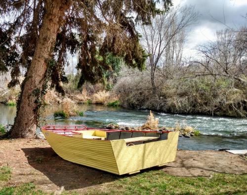 a yellow boat sitting on the grass next to a river at Billingsley Creek in Hagerman