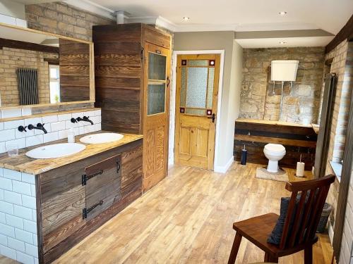 Un baño con dos lavabos y un inodoro. en Farndale House-Hot tub, en Amble