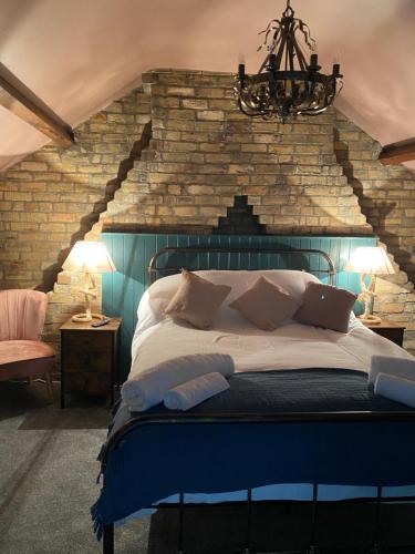 a bedroom with a bed with a brick wall at Farndale House-Hot tub in Amble