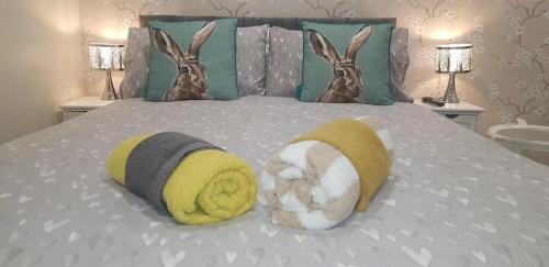 a bed with two towels and two stuffed animals on it at The musical Ceol Cottage 1-Bedroom - Sleeps four in Ballynahinch