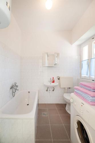 a bathroom with a tub and a toilet and a sink at Dalmatian Garden - FREE parking - city centre in Šibenik