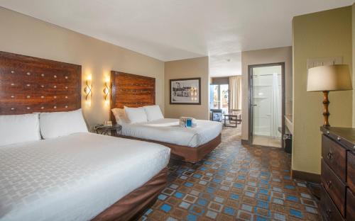 a hotel room with two beds and a balcony at The Nautical Beachfront Resort in Lake Havasu City