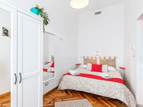 Habitación blanca con cama y espejo en Appartamento Via Po, en Turín