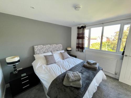a bedroom with a bed with two towels on it at BH - Luxurious 1 bed top floor apartment with parking - please read about score in Shottery